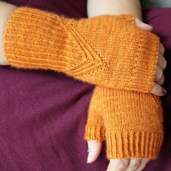 Fingerless mitts in orange yarn with a twisted rib pattern that decreases to a point below the ring finger.