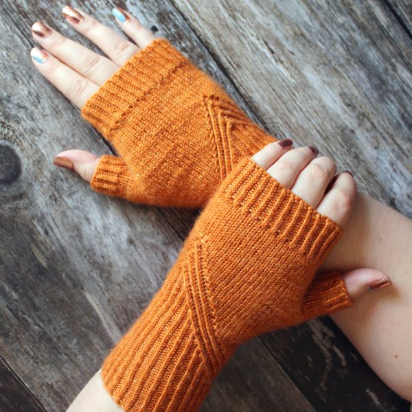 Fingerless mitts in orange yarn with a twisted rib pattern that decreases to a point below the ring finger.