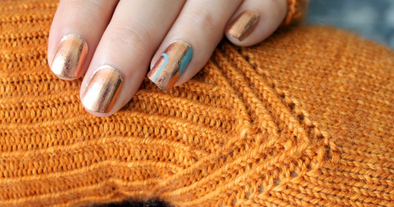 Fingerless mitts in orange yarn with a twisted rib pattern that decreases to a point below the ring finger.