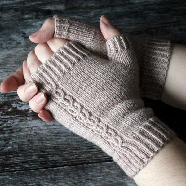 A pair of fingerless mitts with a twisted cable pattern, knit in a pale tan yarn